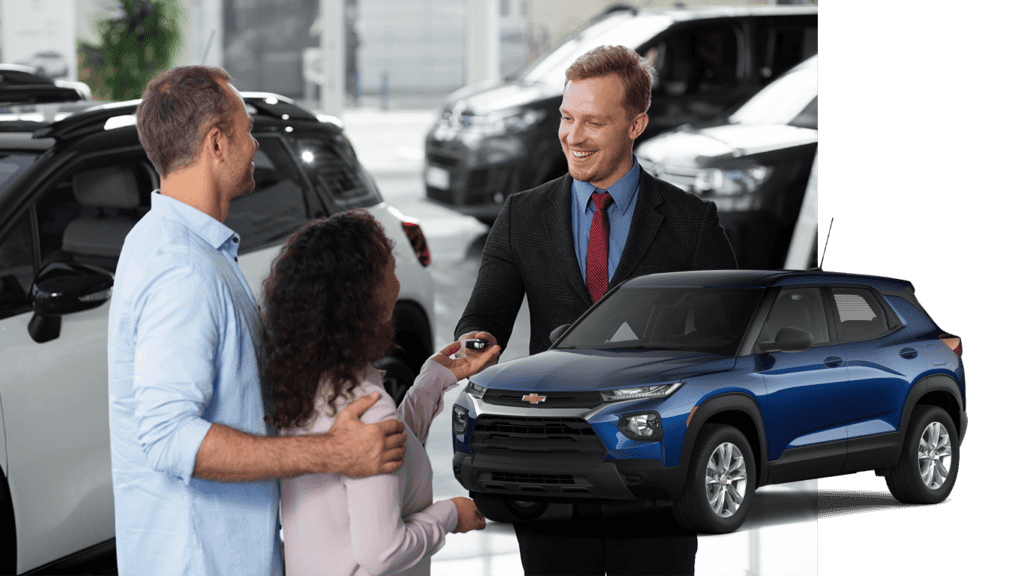 Best Time To Buy At CMA Chevrolet of Martinsburg in Martinsburg, WV | Blue 2022 Chevrolet TrailBlazer with a background photo of a sales person handing car keys over to a couple for a test drive
