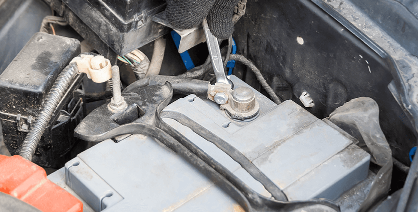 Everything You Need to Know about Your Car Battery at CMA Chevrolet of Martinsburg | Person with black gloves tightening battery cable by using a wrench