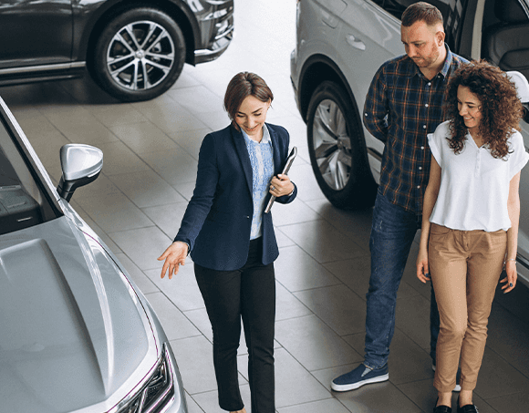 Leasing versus Buying a Chevrolet at CMA Chevrolet of Martinsburg in Martinsburg, WV | Sales person showing a man and woman together, some of the car options at the dealership