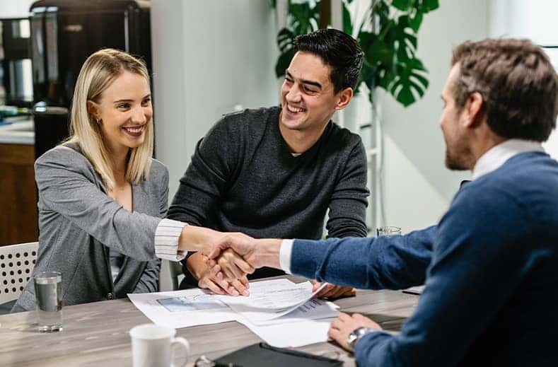 Defining GAP Insurance at CMA Chevrolet of Martinsburg in Martinsburg, WV | Woman shaking hands with a sales person at dealership