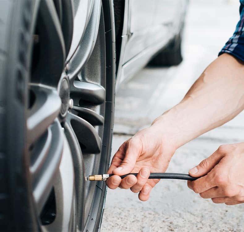 Tire Pressure Information at CMA Chevrolet of Martinsburg in Martinsburg, WV | Person putting air into tire with a tire pressure hose  