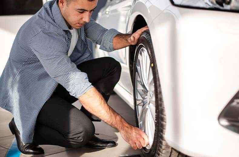Tire Pressure Information at CMA Chevrolet of Martinsburg in Martinsburg, WV | Man checking the tire pressure on his car tire  