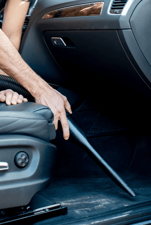 Accessories that help keep your Chevrolet protected at CMA Chevrolet of Martinsburg in Martinsburg, WV | Person vacuuming the interior of his car floor