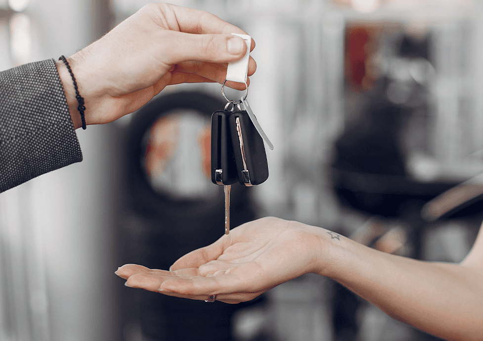 High Cost of Replacing a Car Key | CMA Chevrolet of Martinsburg | Sales person handing over new car key fobs to new car owner