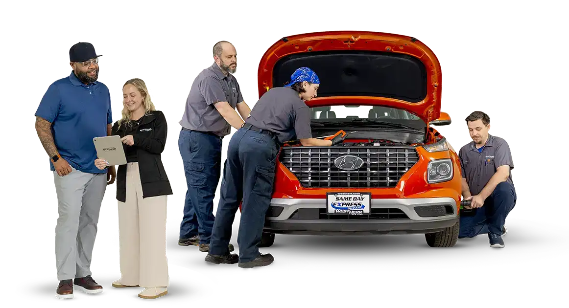 Customers standing in front of car being serviced