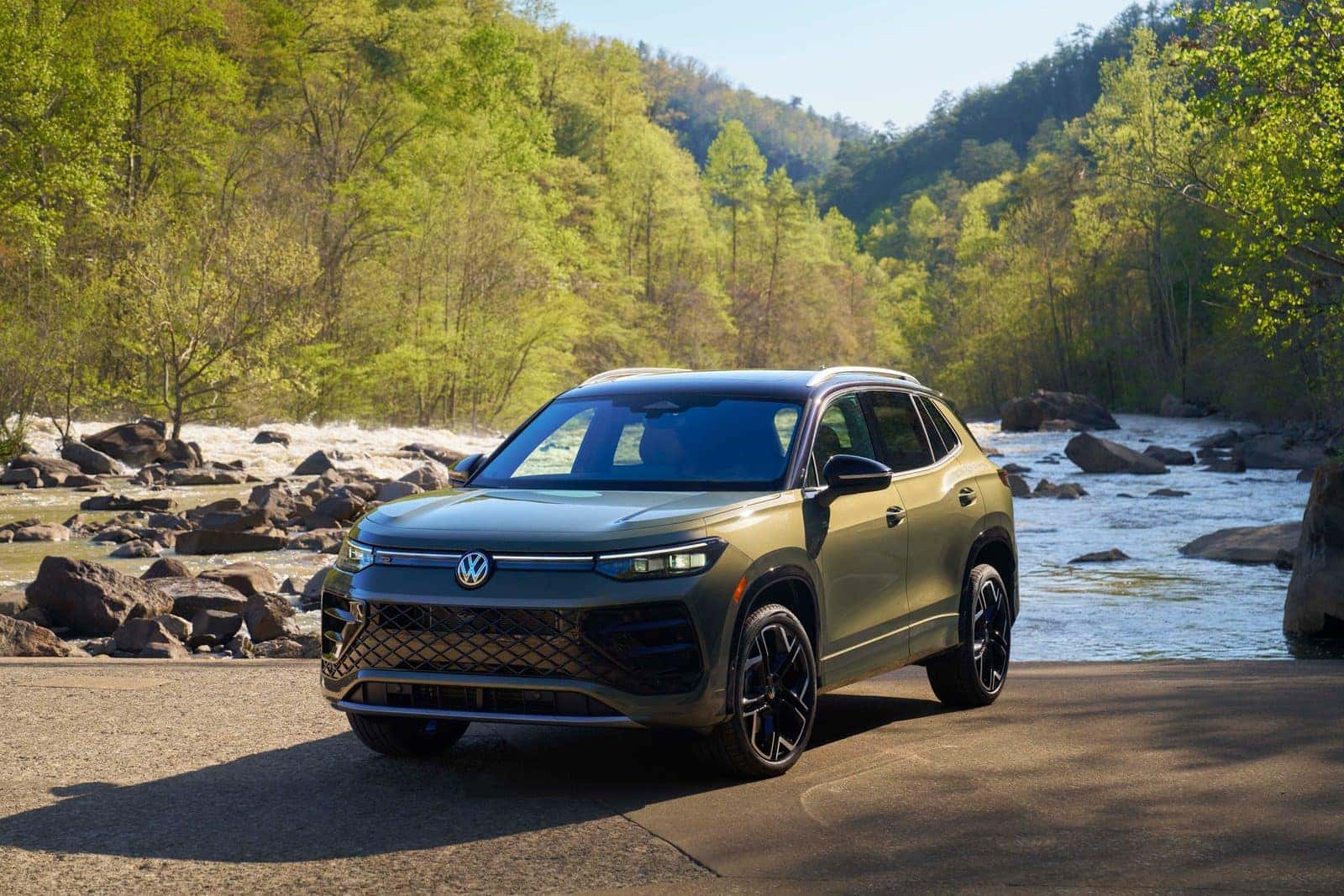 2026 Volkswagen Tiguan SEL R-Line Turbo in Avocado Green beside a mountain river