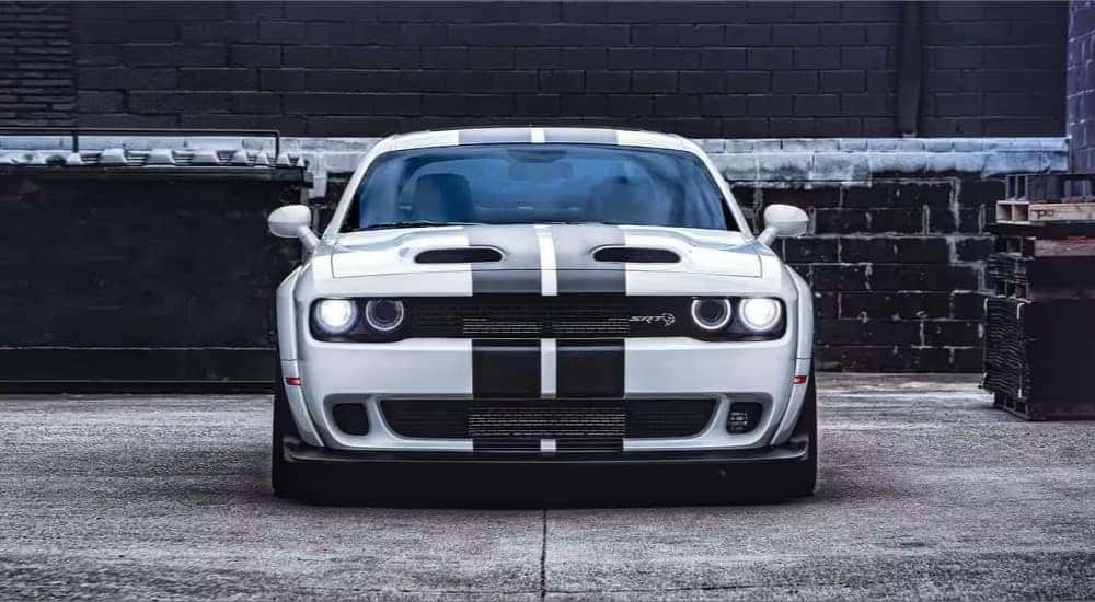 A white 2023 Dodge Challenger SRT is shown parked near a brick wall.
