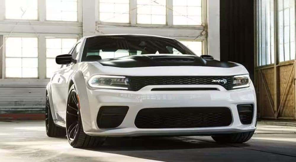 A white 2023 Dodge Charger SRT is shown parked in a garage.