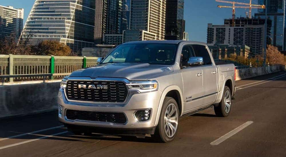 A silver 2025 Ram 1500 Tungsten driving through a city.