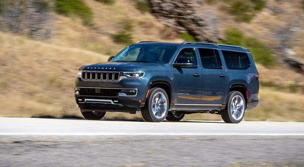 A blue 2024 Jeep Wagoneer for sale driving and angled left.