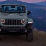 A grey 2025 Jeep Gladiator for sale is parked near mountains.
