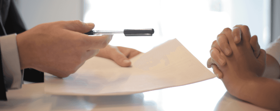 Car Salesman Giving Woman a Car Loan Form to Sign