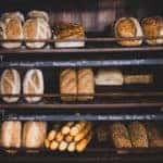 Freshly baked bread of different varieties sitting on shelves in a bakery