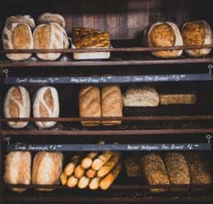 Freshly baked bread of different varieties sitting on shelves in a bakery