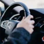 close up of a driver's hands holding on to a Honda steering wheel