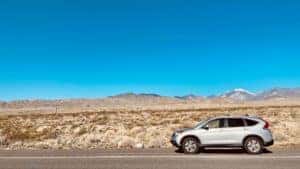 Silver Honda LX driving through desert