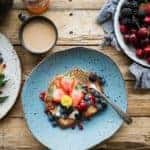 pancakes with fruit on colored plates on a wooden table