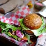 A burger and a side of veggies on a tray