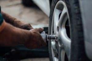 A vehicle service worker taking the wheel cover off of a Hyundai vehicle