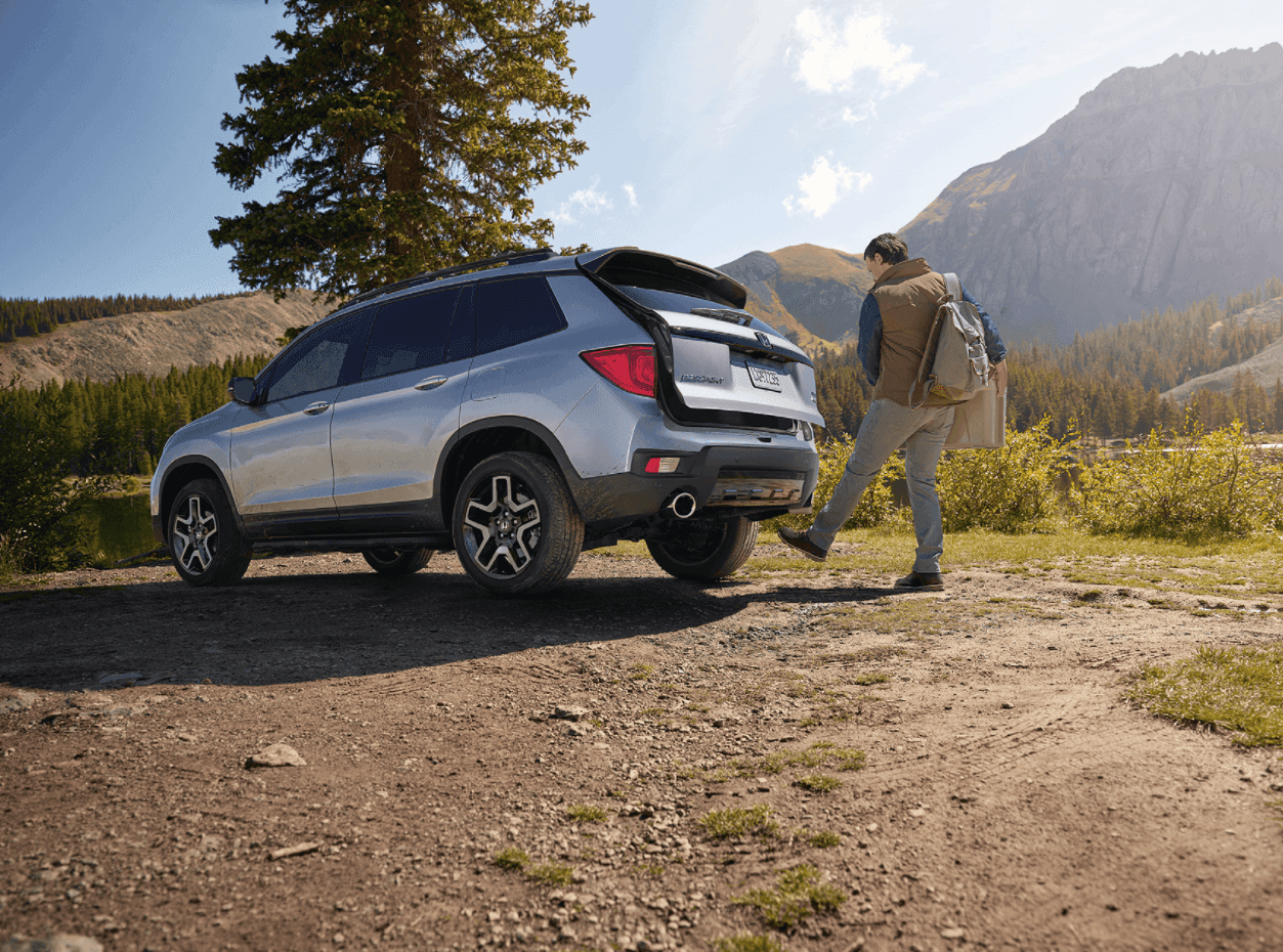 Man unloading trunk of Honda Passport