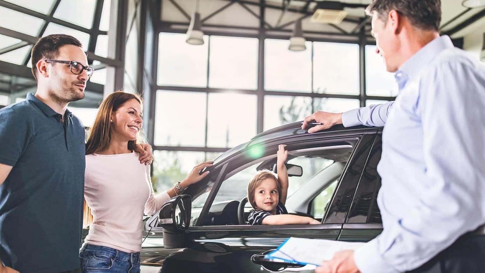 Family talking to car salesman