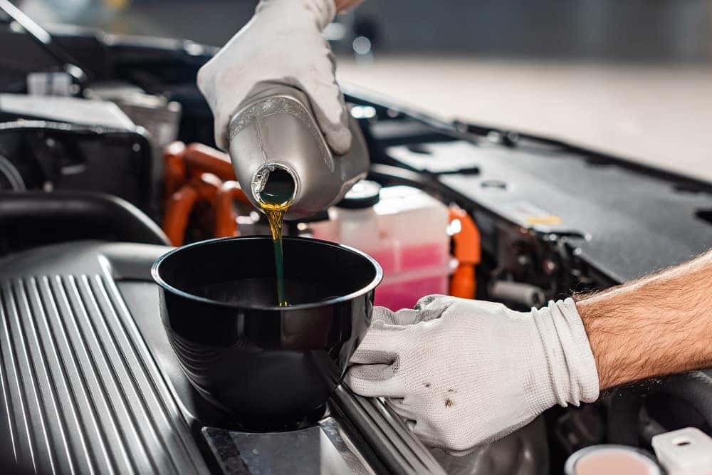 Pouring New Oil into Engine at Service Center near Boston MA | Ira Mazda