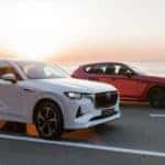 two mazda cx-60 suvs red and white open road sea
