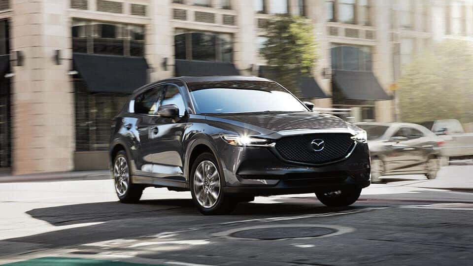 gray Mazda CX60 SUV turns in the street