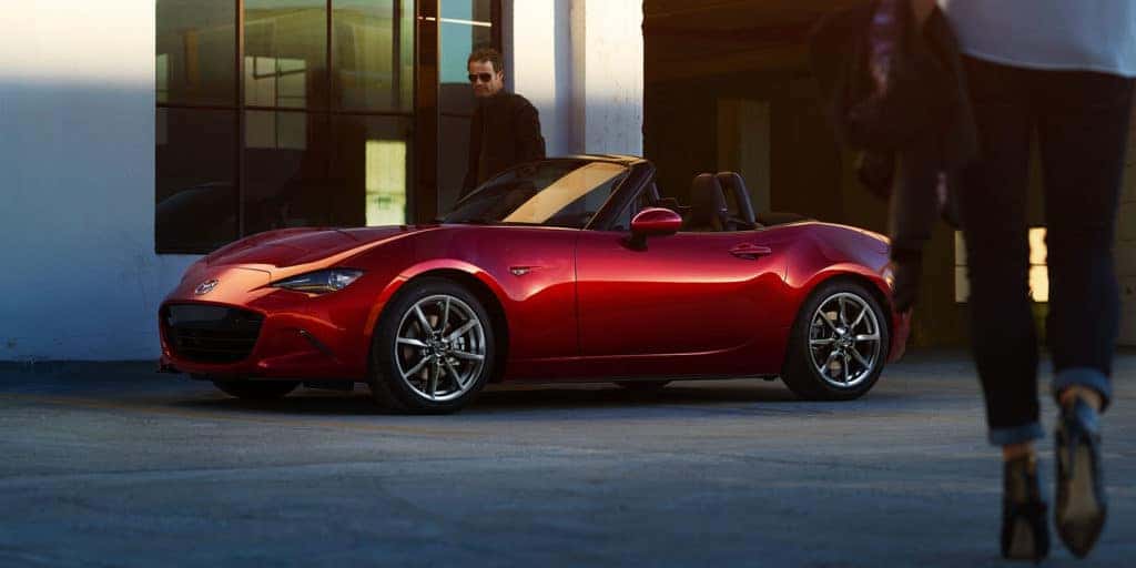 red mazda miata sports car man and shoes on street