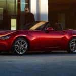 red mazda miata sports car man and shoes on street