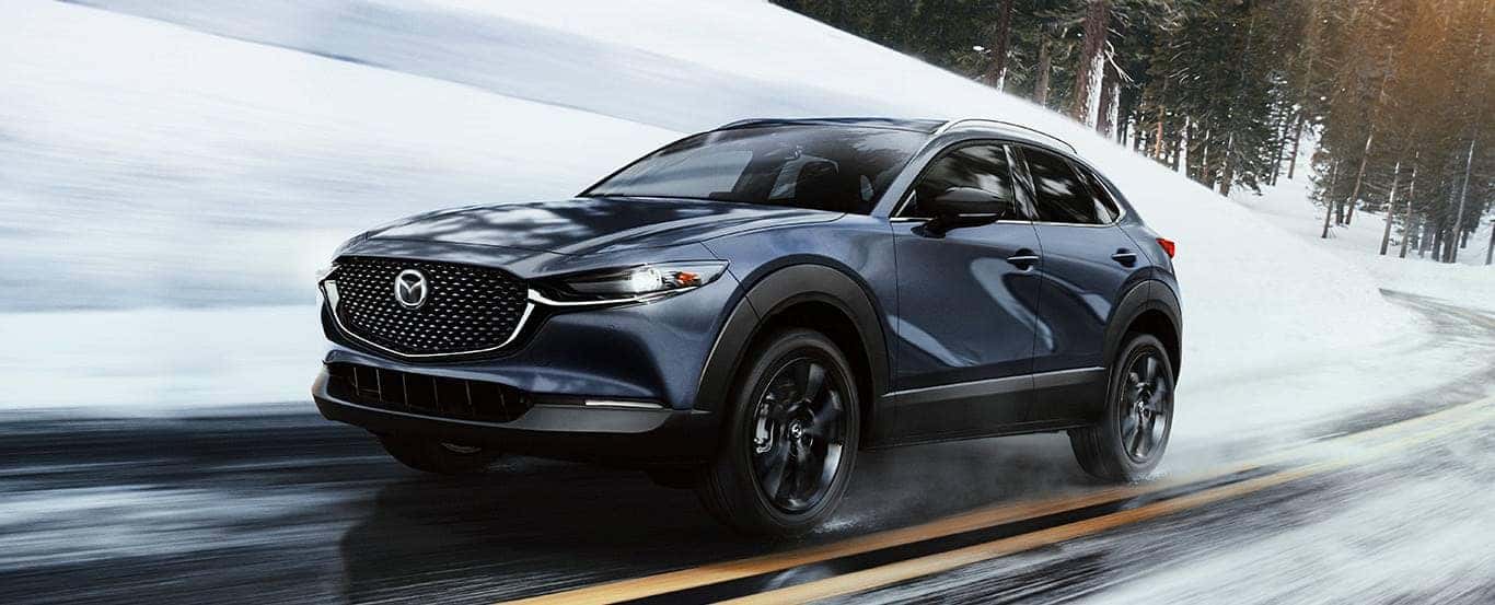 Gray Mazda CX-30 SUV Snow Buildings