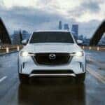 White Mazda CX-90 SUV PHEV Bridge Road Bildings