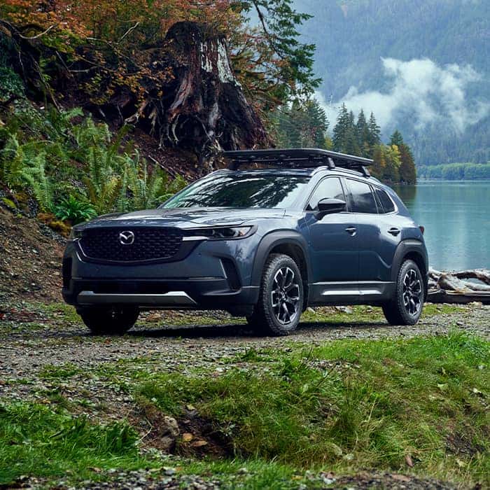 Blue Mazda CX-50 SUV Water Trees