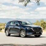 BLue Mazda CX-8 SUV trees blue sky
