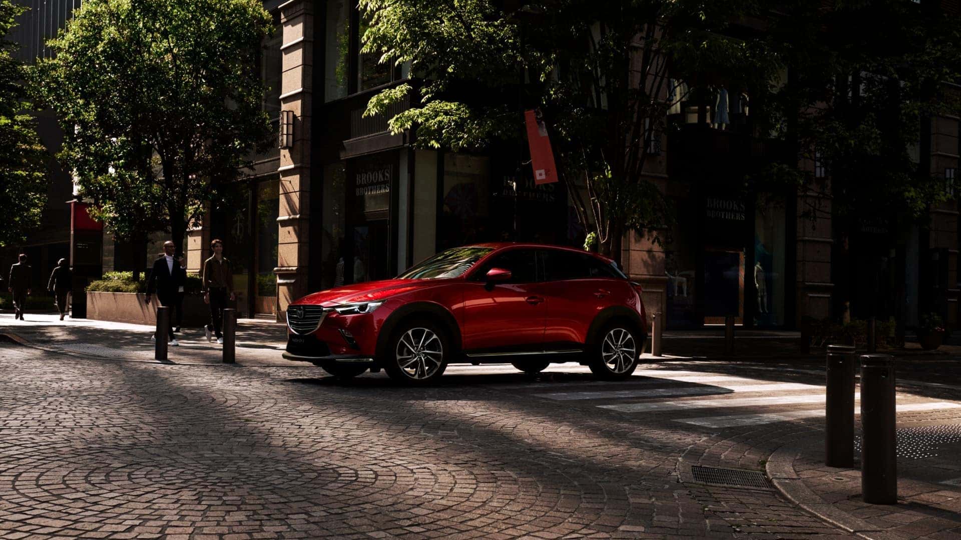 Red Mazda CX-3 SUV People Red Bricks Buildings Trees