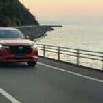 Red Mazda CX-70 SUV Water Road Mountains