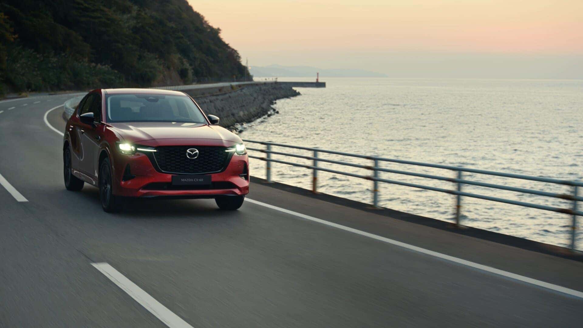 Red Mazda CX-60 SUV Water Road Mountains