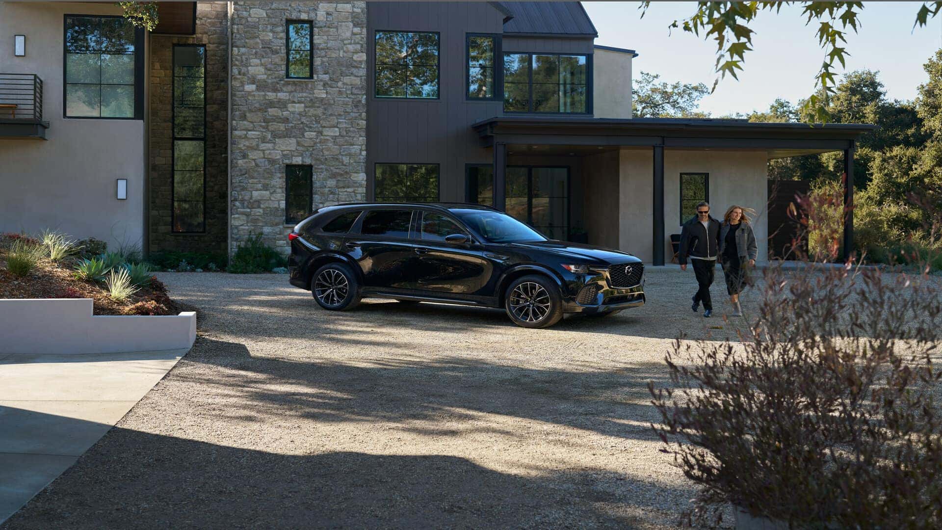 Black Mazda CX-70 SUV Man Woman Brick House
