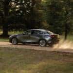 Silver Mazda 3 Sedan Green Grass Trees