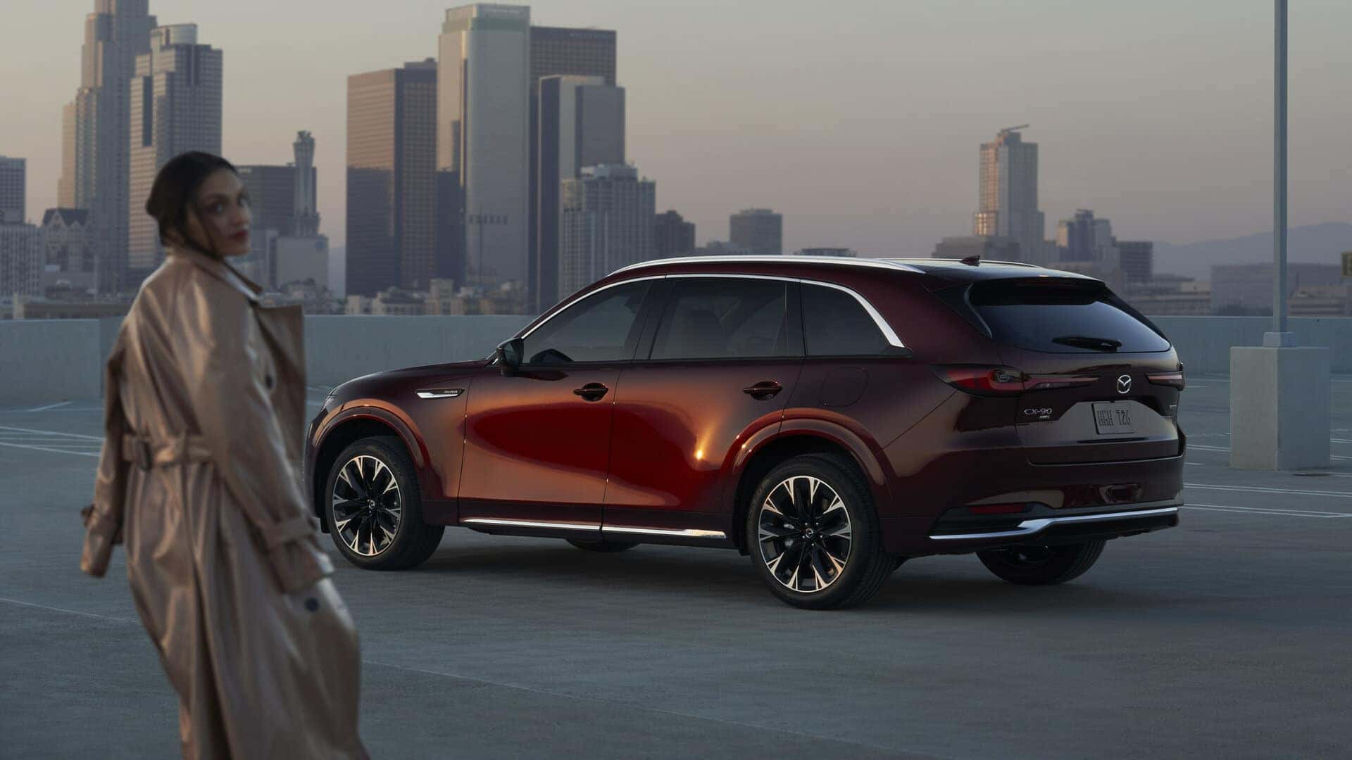 Maroon Mazda CX-90 SUV WOman Buildings