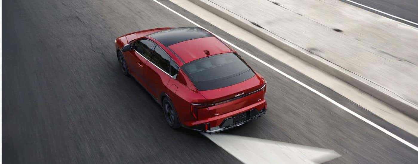 Aerial view of a red 2026 Kia K4 GT-Line Turbo shown driving.