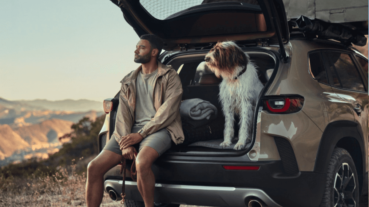 Oregon man sitting in the back of a Mazda CX-50 with his dog
