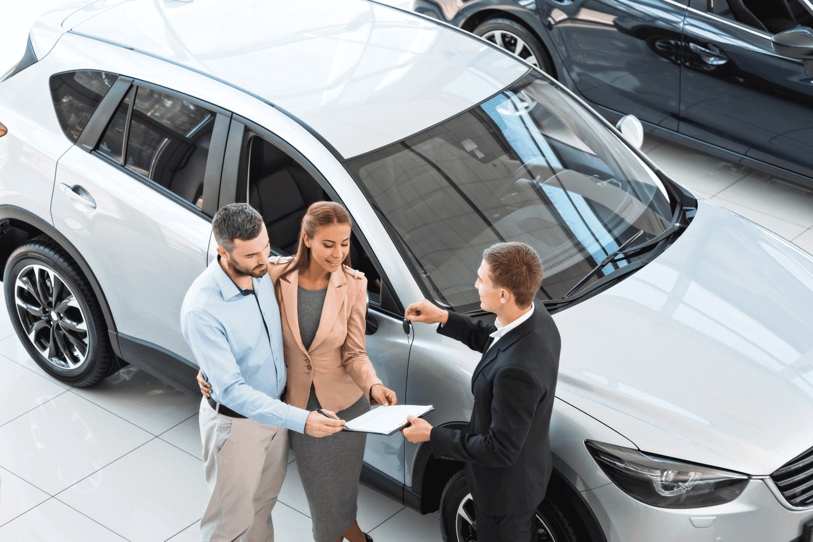 Couple getting new car keys Westwood MA showroom
