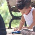 A small child playing with a toy car