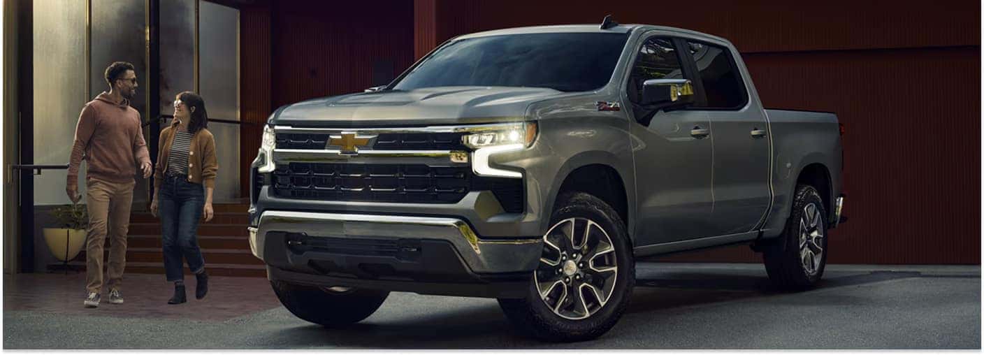 Front three-quarter view of a gray 2026 Chevrolet Silverado 1500 crew cab parked outside a modern home.