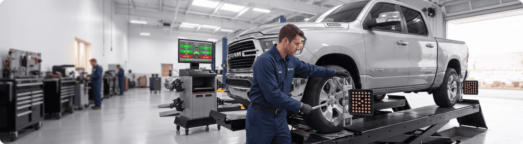 Technician performing a computerized tire alignment on a vehicle at Singing River CDJR
