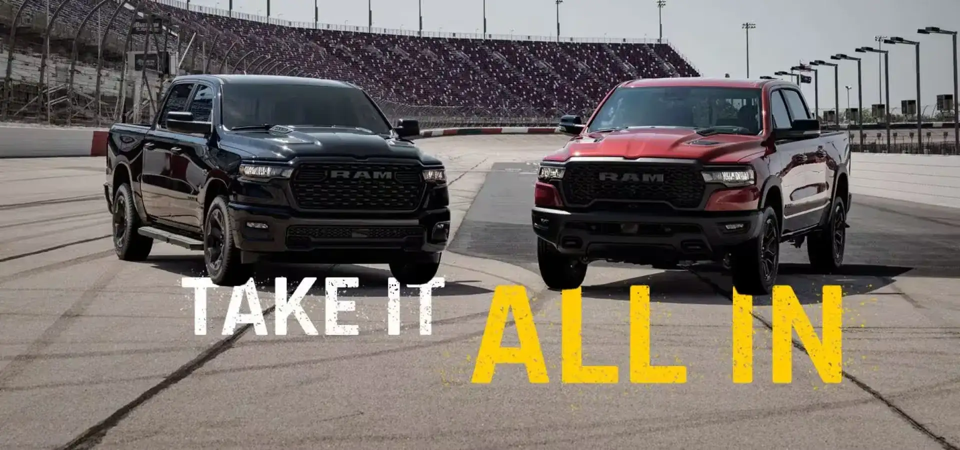 Black and red 2027 RAM 1500 trucks on a racetrack with the words Take It All In