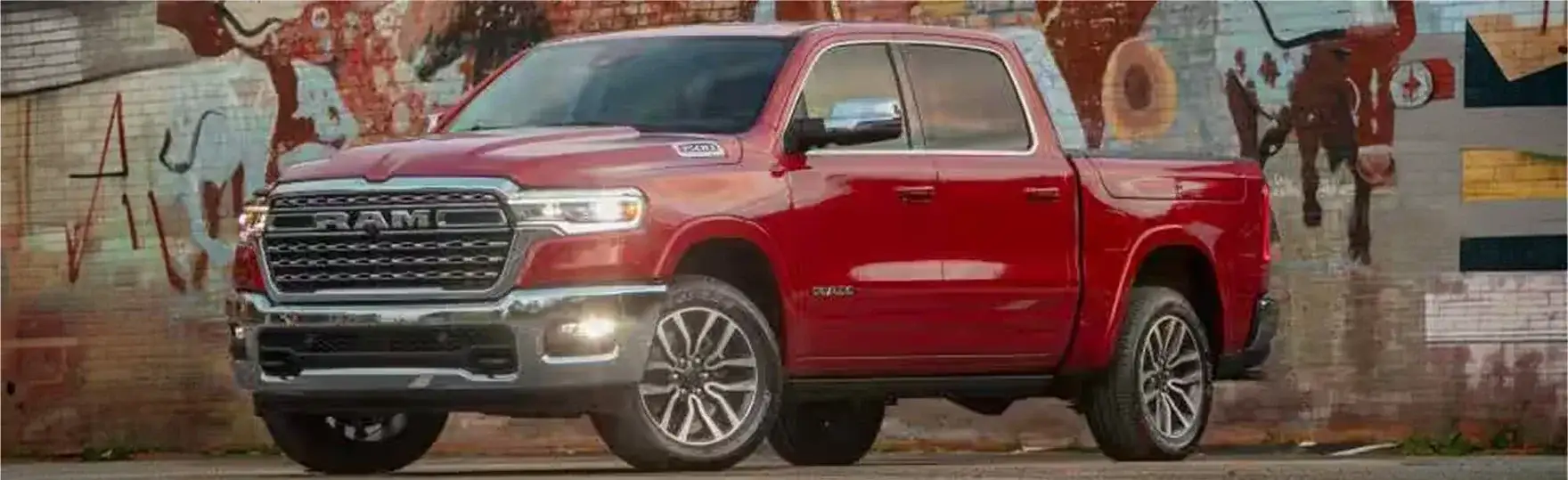 Red 2027 RAM 1500 parked in front of a graffiti mural