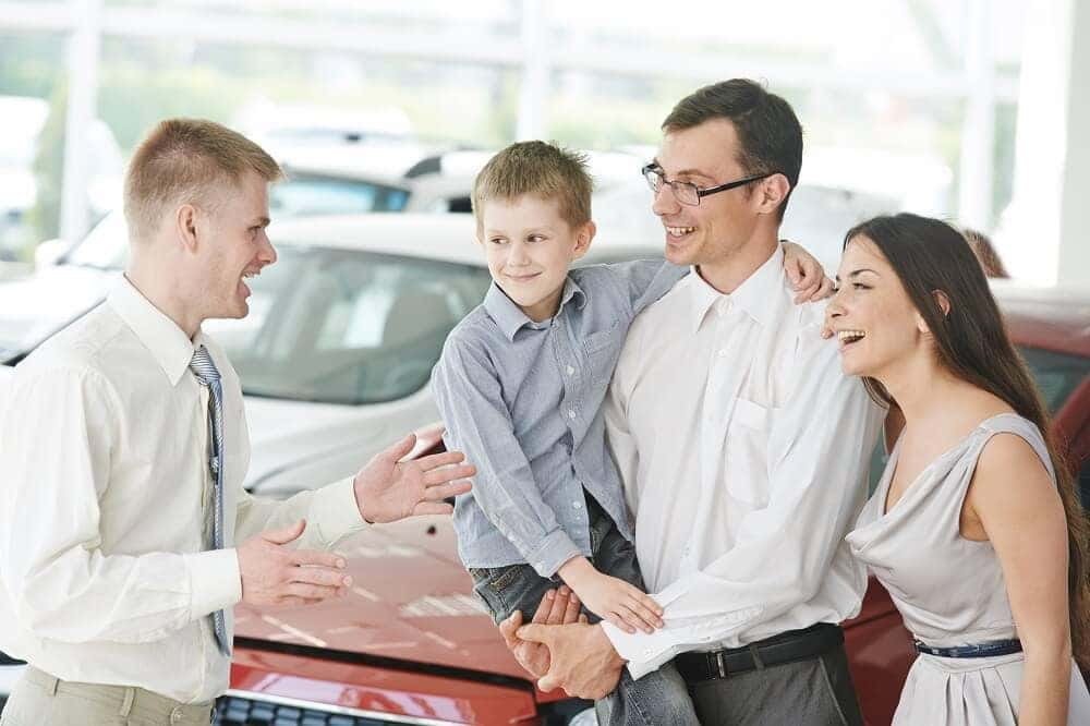 Family talking to Car Salesman about a MINI Cooper Clubman Lease