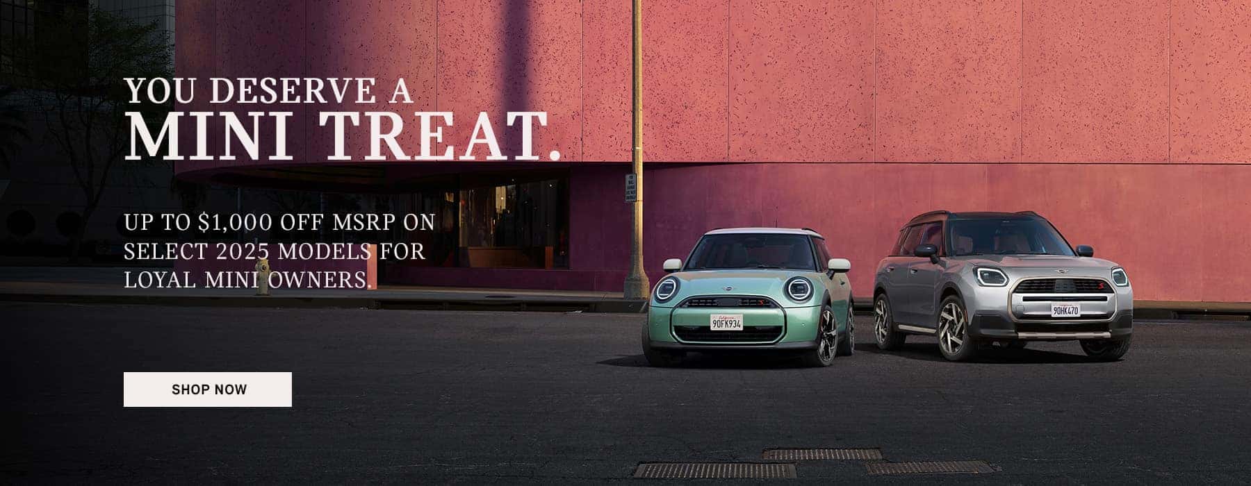 Front view of MINI vehicles parked in front of a pink wall.